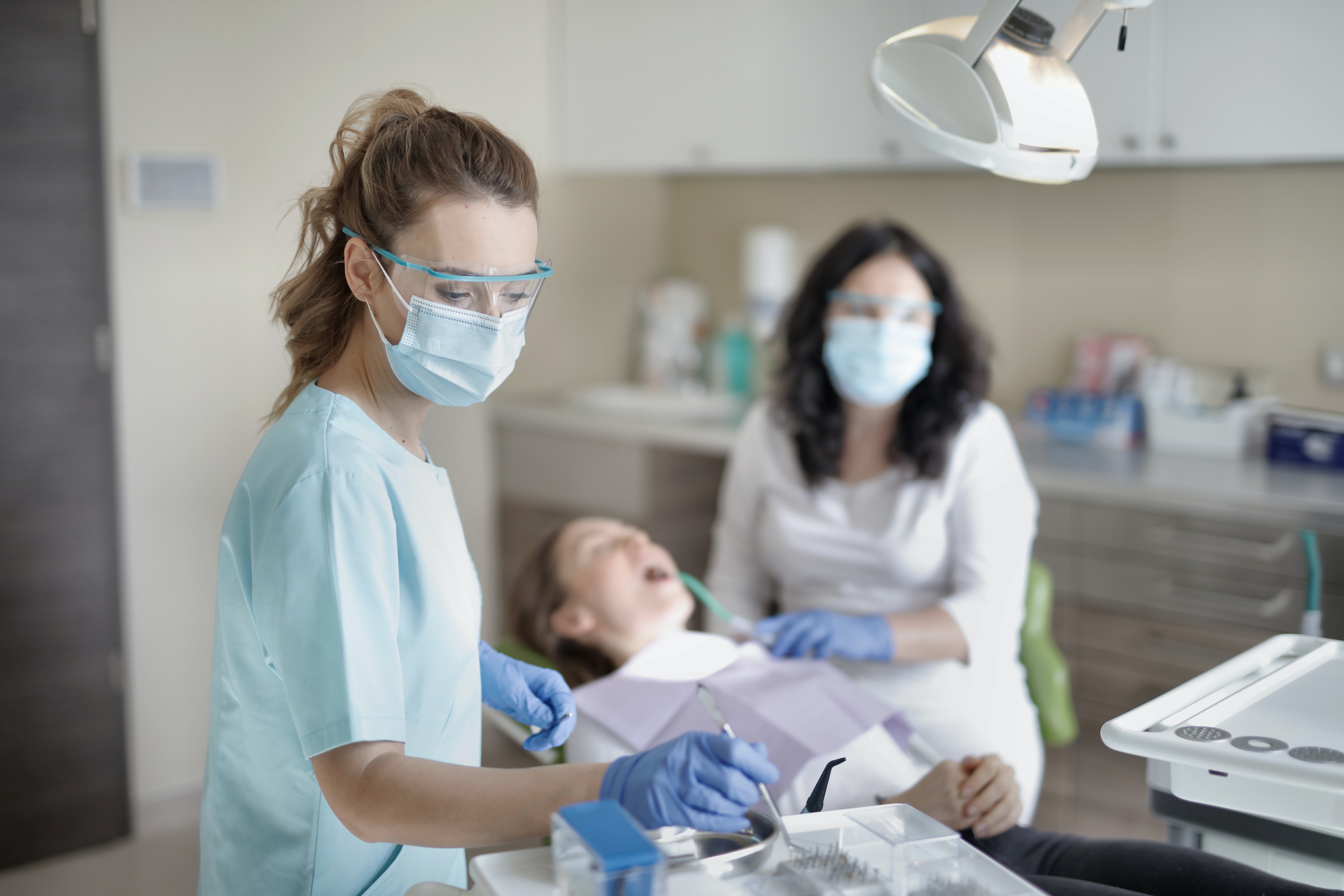 Dentist performing a professional act with the help of his assistant.